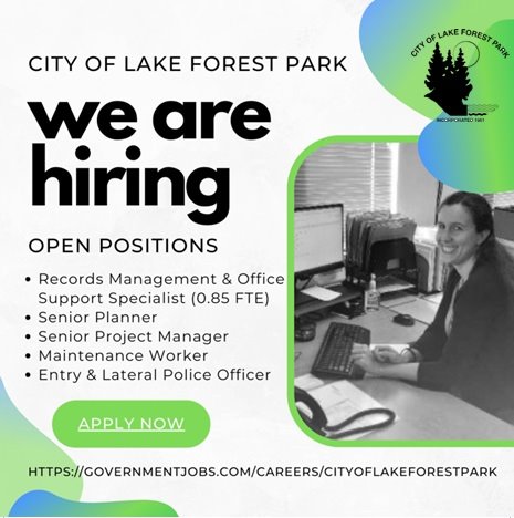 We are hiring - employee sitting at a computer looking at camera