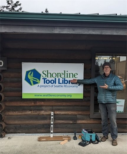 Man pointing to tool library open sign