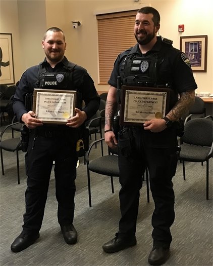 Officers Carlsrud and Benson holding plaques