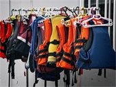 Life jackets hanging on a rack.
