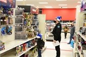 Officer with child shopping at Target; both are wearing blue Santa hats