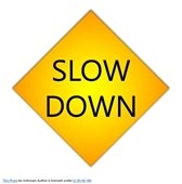 Street sign that reads Slow Down
